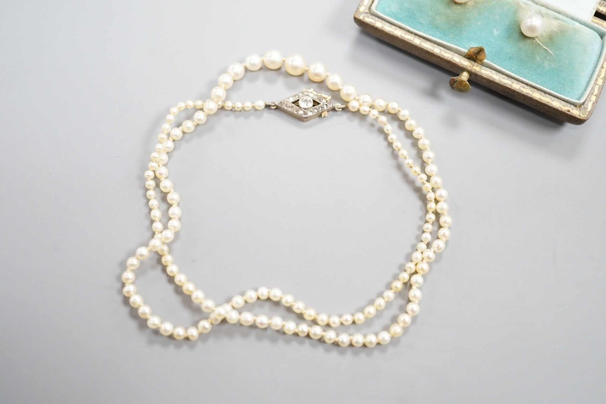 A single strand graduated seed pearl necklace, with yellow metal and diamond set clasp 42cm and a cased pair of similar Austro Hungarian ear clips.